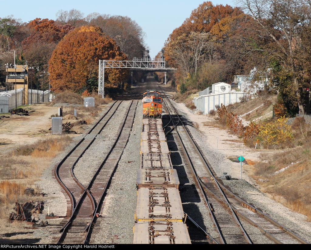 NS train O56 heads westbound with a string of empty flat cars